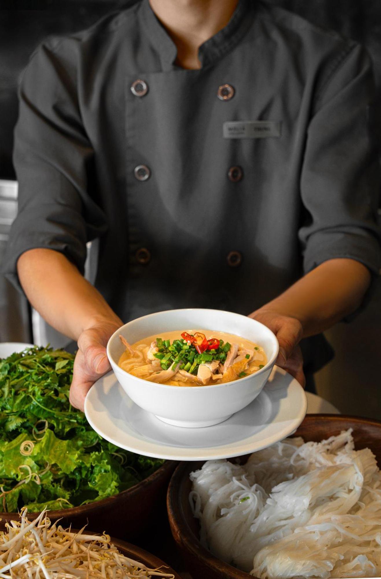 فندق فينبيرل هوى هوي المظهر الخارجي الصورة A chef holding a bowl of Tom Kha soup